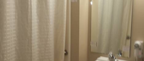 A bathroom with a bathtub, a sink, and a mirror.