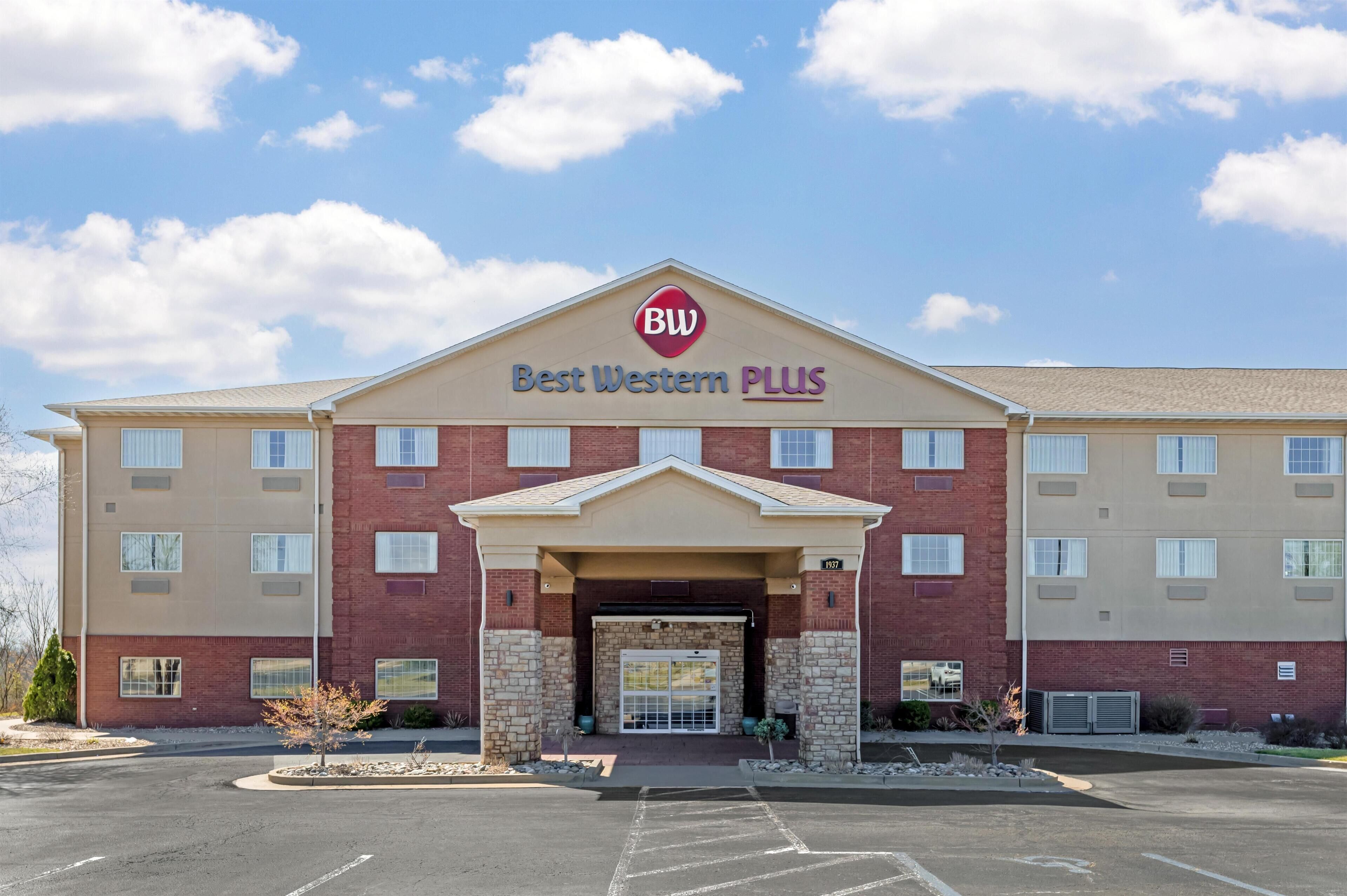 A Best Western PLUS hotel with a brick facade, a central entrance, and a parking lot.
