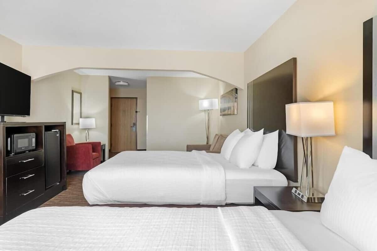 A hotel room with a bed, a TV, a desk, and a lamp.