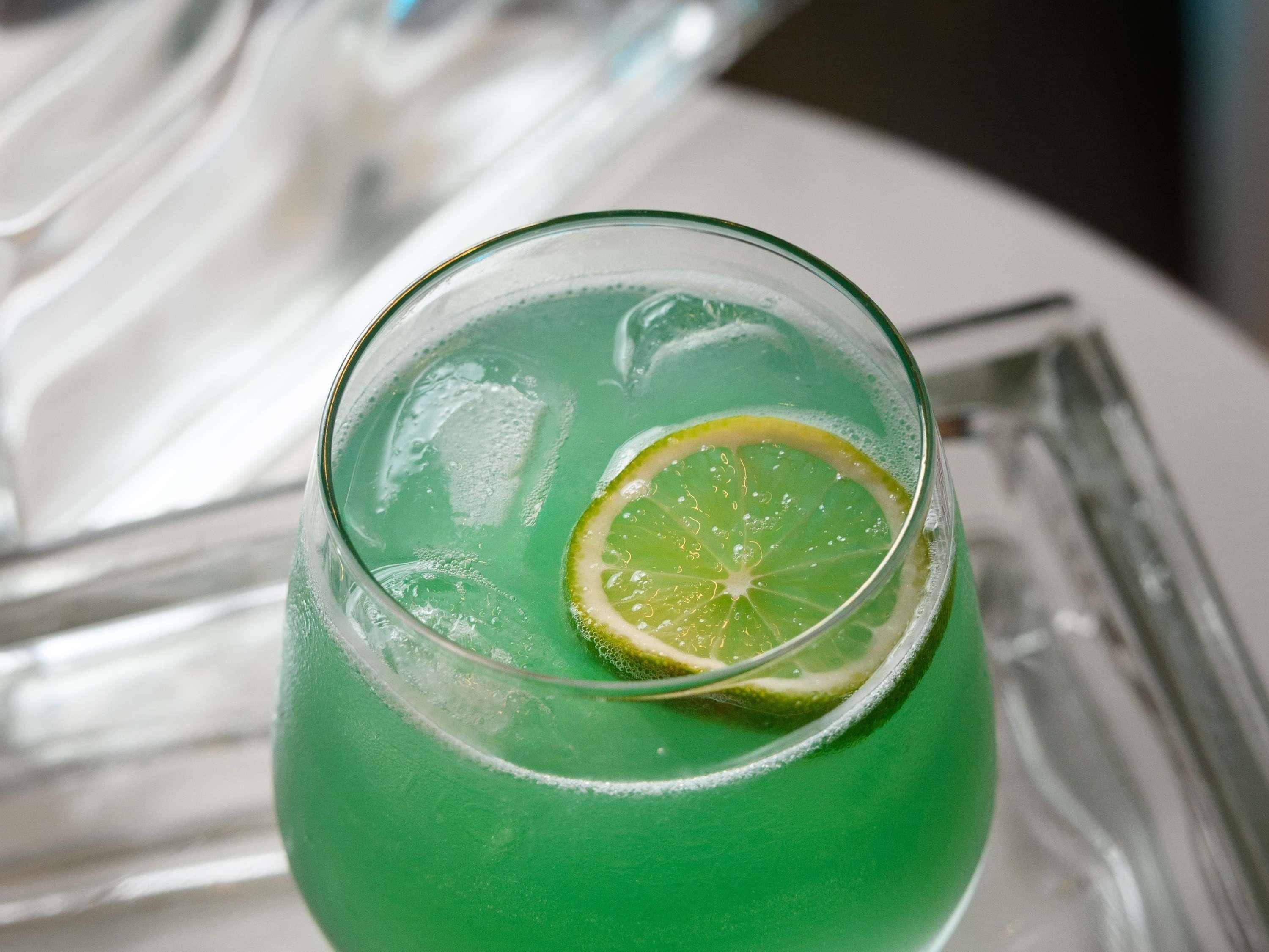 Ein Glas mit einem grünen Getränk und einer Limettenscheibe.