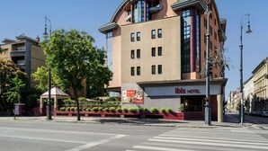 Ein modernes Hotel mit geschwungener Fassade, großen Fenstern und einem markanten Eingang.