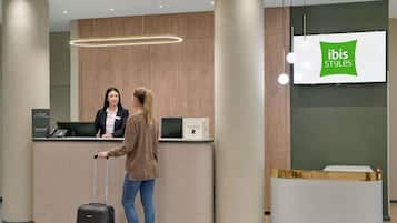 Ein Empfangsschalter mit einem digitalen Bildschirm, der 'ibis Styles' anzeigt.