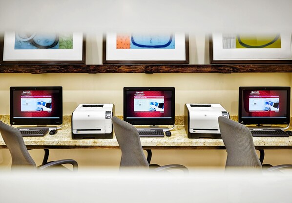 Zona de recepción de hotel con varias estaciones de trabajo de computadora, cada una mostrando el sitio web de Marriott.