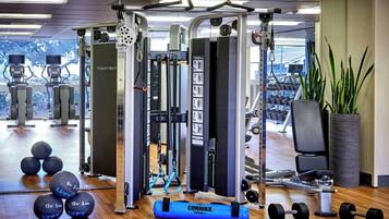 A gym with exercise equipment, weights, and a mirror.