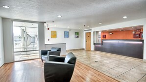 Un hall d’entrée spacieux comprenant un comptoir d’accueil, un espace détente et une vue sur l’extérieur.