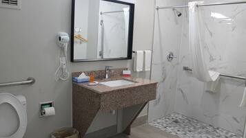Ein Badezimmer mit Waschbecken, Spiegel, Toilette und Dusche.