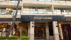 A multi-story hotel with balconies and a palm tree in front. - Regency on Beachwalk Waikiki by OUTRIGGER (Honolulu)