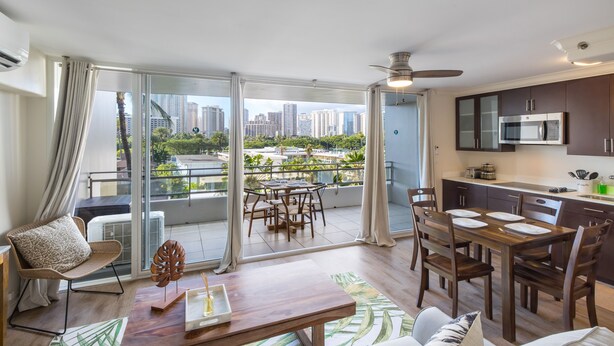 A modern apartment with a balcony, dining area, and kitchen. - Regency on Beachwalk Waikiki by OUTRIGGER (Honolulu)