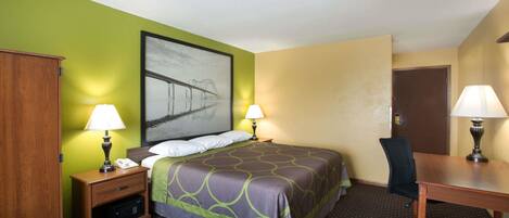 A hotel room with a bed, two bedside tables with lamps, a desk, and a chair.