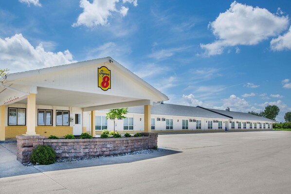 Welcome to Super 8, a hotel with a covered entrance and a charming planter.