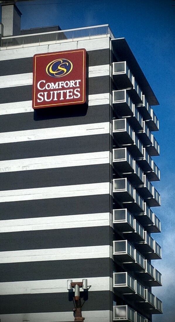 Il s’agit d’un immeuble sur lequel on peut voir une enseigne « Comfort Suites ». Il comporte plusieurs étages et possède des balcons.