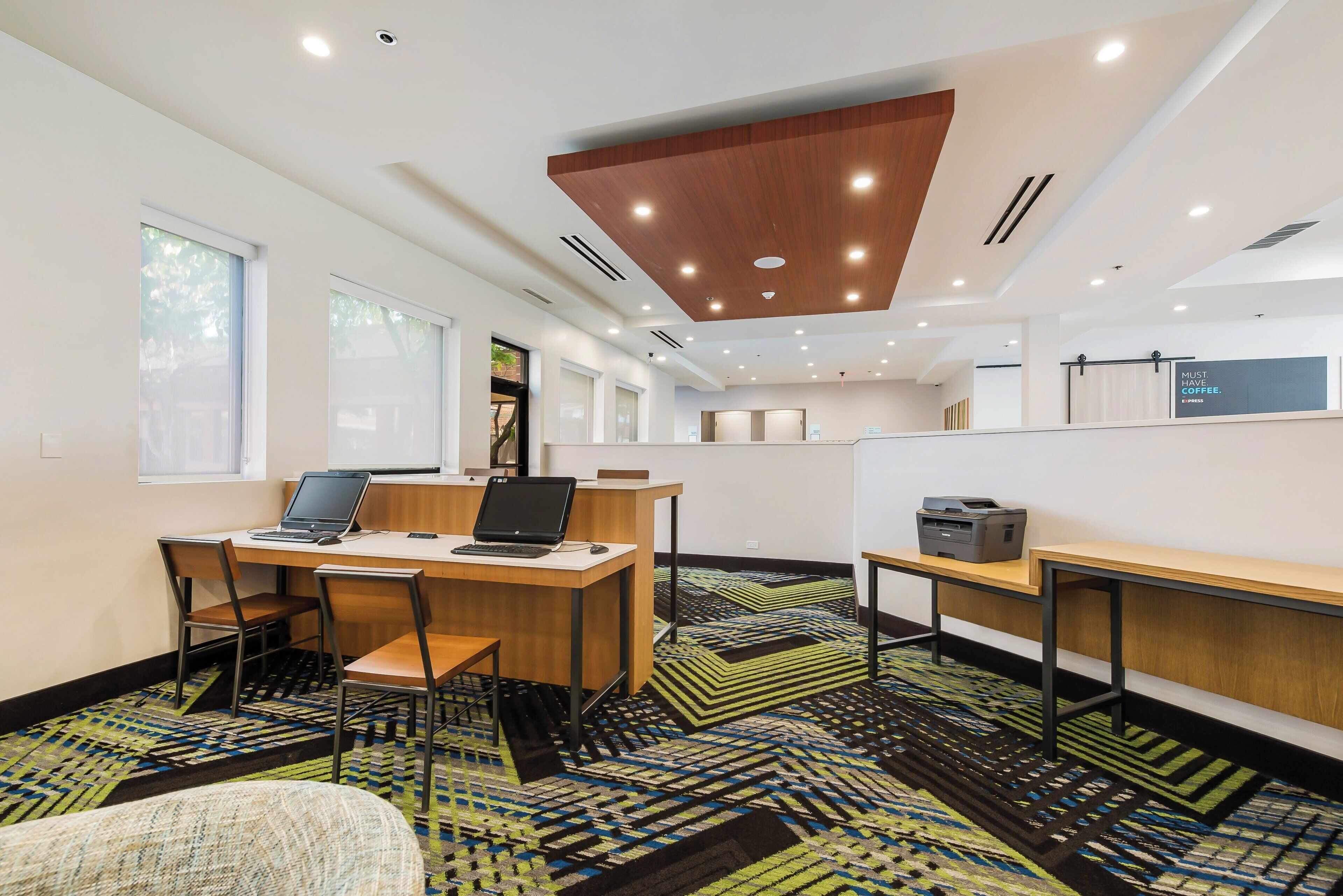 A modern office space with desks, chairs, and computers.