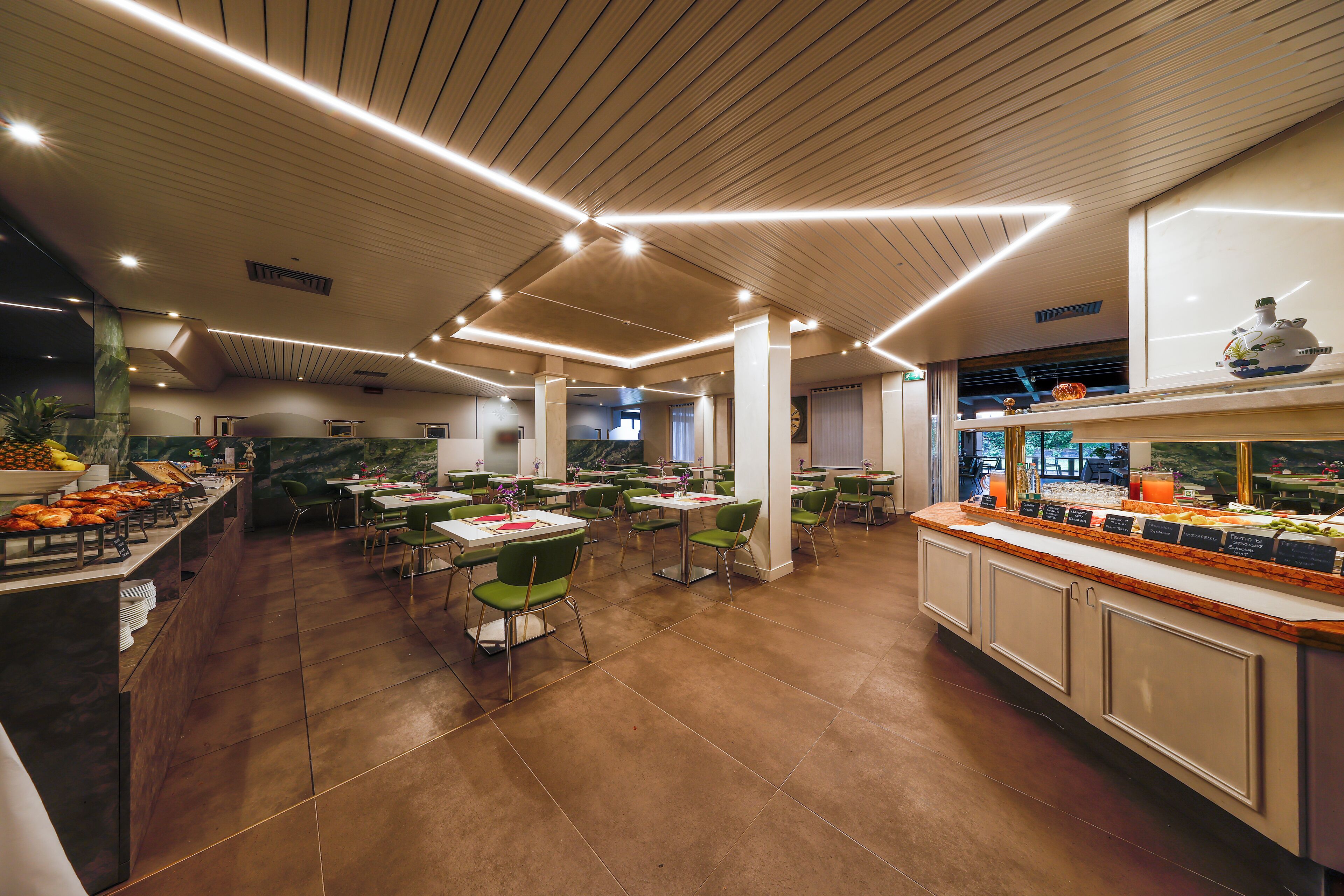 A spacious restaurant with high ceilings, modern lighting, and a variety of seating options.