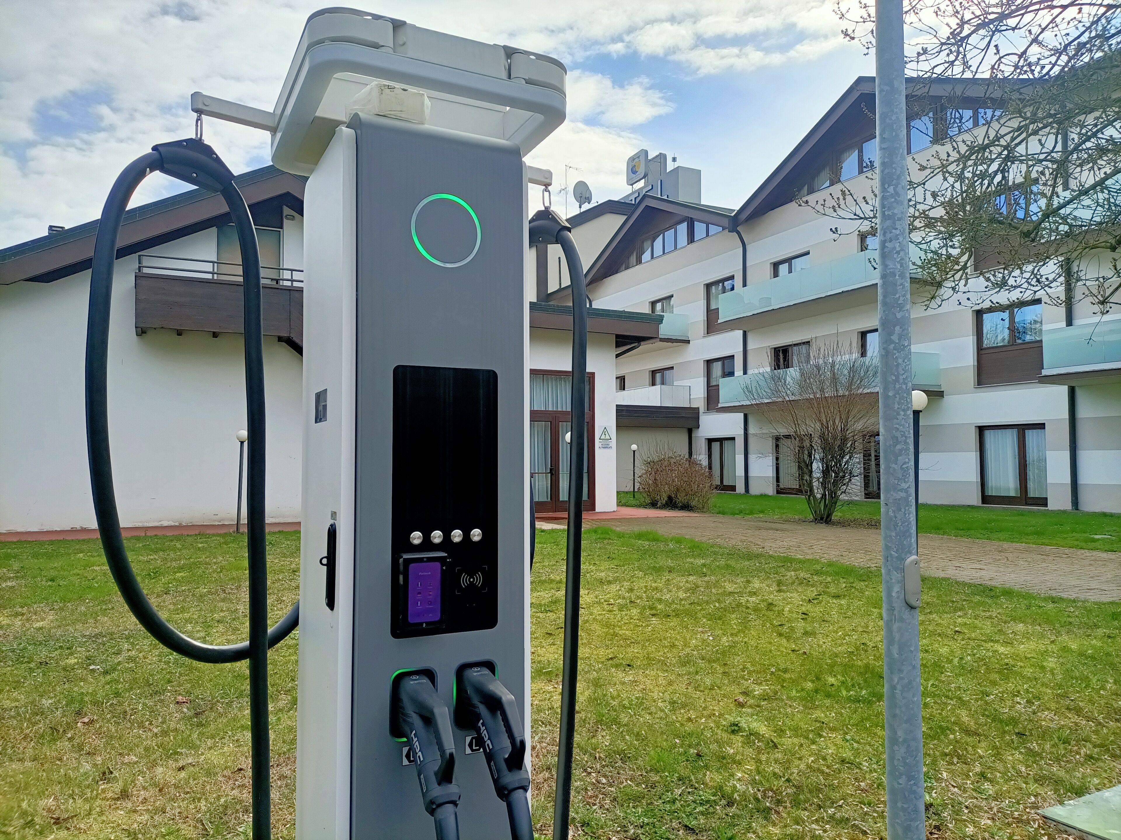 An electric vehicle charging station with two charging ports, a control panel, and a cable.