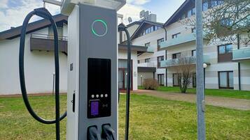 An electric vehicle charging station with two charging ports, a control panel, and a cable.