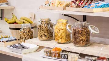 Un buffet de petit-déjeuner proposant une variété d’aliments, notamment des céréales, des fruits et des en-cas emballés.