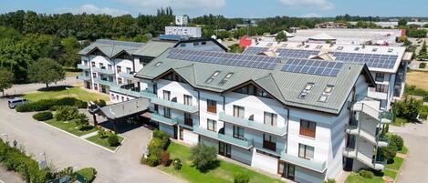A hotel with multiple floors, solar panels on the roof, and a parking lot.