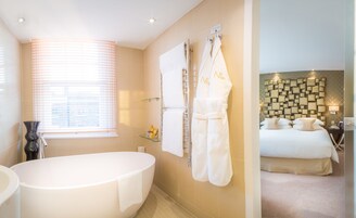 A modern bathroom with a bathtub, a shower area, and a vanity.