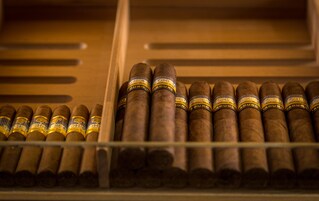 A display of cigars in a wooden box with labels.