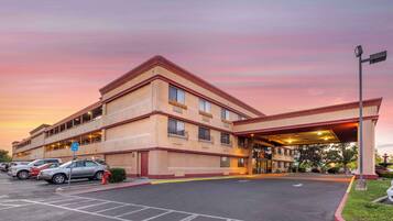 A hotel with a parking lot and a covered entrance.