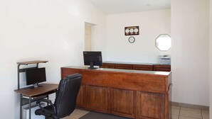 A reception desk with a computer, a chair, and a clock on the wall. - Howard Johnson by Wyndham Brigham City (Brigham City)