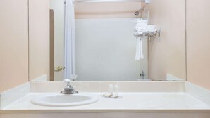 A bathroom with a sink, mirror, shower, and towel rack. - Howard Johnson by Wyndham Brigham City (Brigham City)
