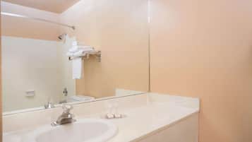 Une salle de bain avec un lavabo blanc, un miroir et un porte-serviettes.