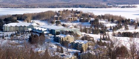 A snow-covered resort with multiple buildings, including a large hotel with a central courtyard and several smaller structures.