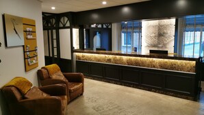 A reception area with a marble counter, leather chairs, and a wall-mounted map. - Best Western Hotel Baars (Harderwijk)