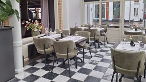 A restaurant with checkered flooring, round tables, and chairs. - Best Western Hotel Baars (Harderwijk)
