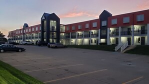 Ett hotell med flera våningar och en parkeringsplats framför.
