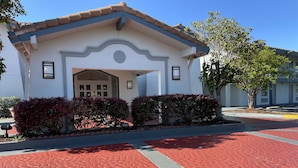A building with a white facade, a tiled roof, and a symmetrical entrance.