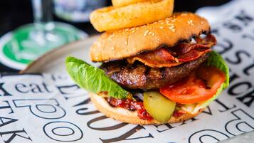 Una hamburguesa con lechuga, tomate y pan con semillas de sésamo.