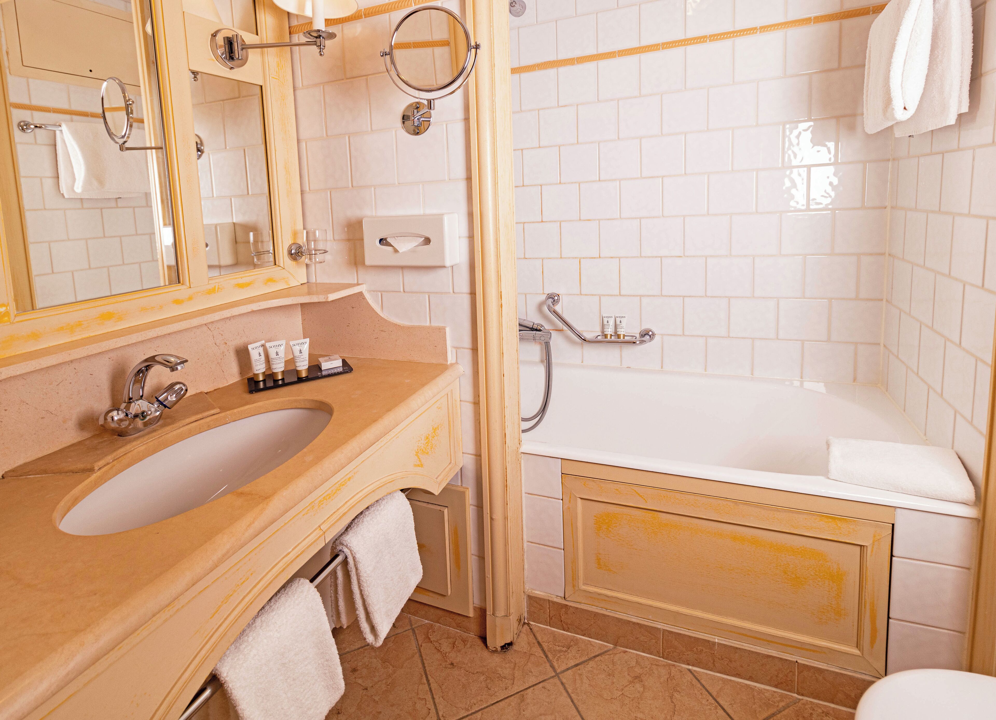Ein Badezimmer mit Waschbecken, Spiegel und Badewanne.