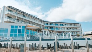 Un hôtel moderne doté de nombreux balcons, de grandes fenêtres et offrant une vue sur la côte.