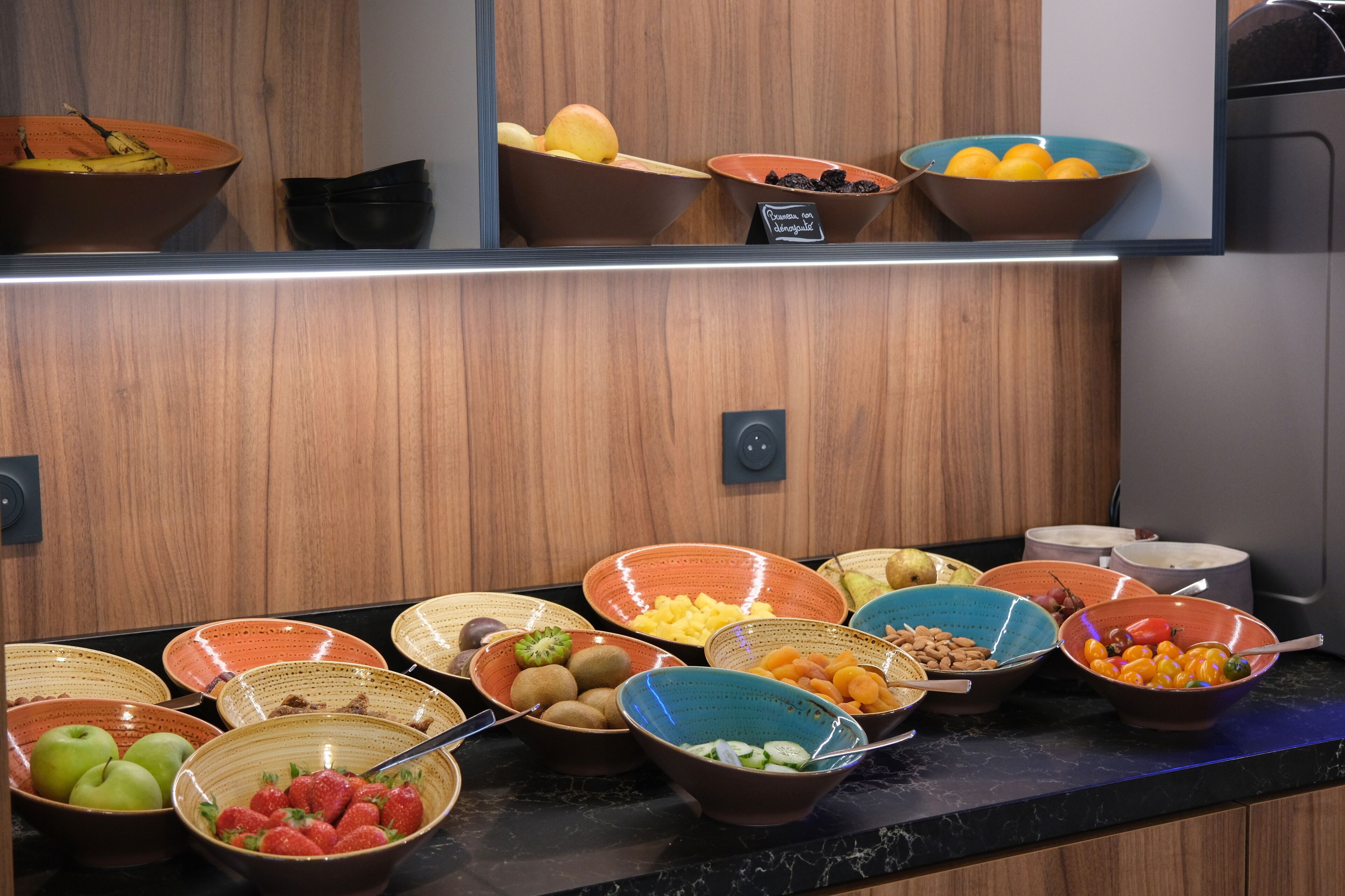 Un bufé con diversas frutas y verduras en cuencos.