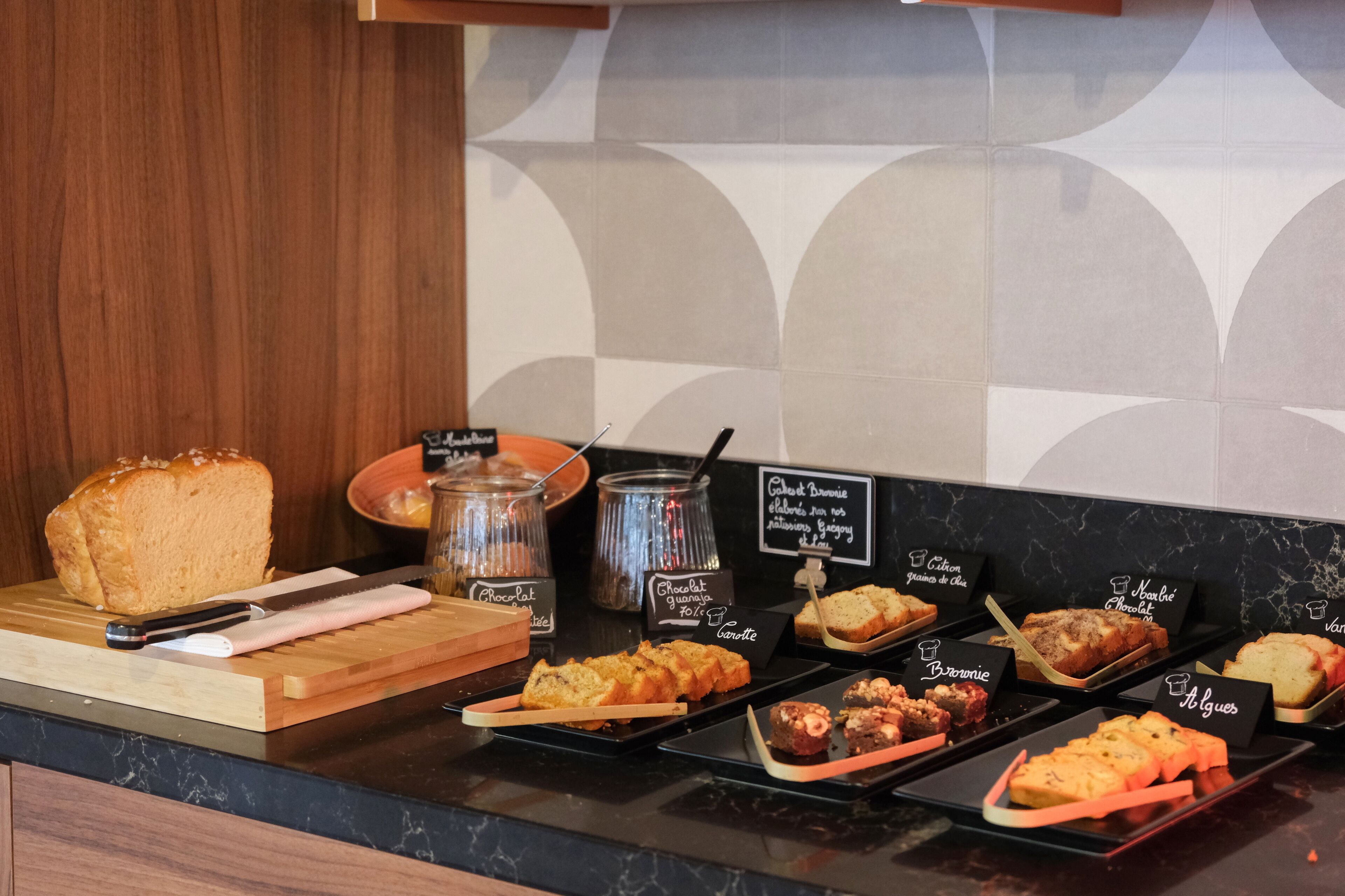 A bakery display with various baked goods and a cutting board with a knife.