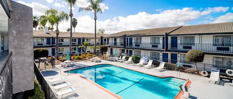 Alberca al aire libre, sombrillas en la alberca y camastros