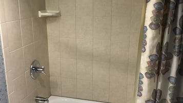 A bathroom with a bathtub, a shower curtain, and a towel rack.
