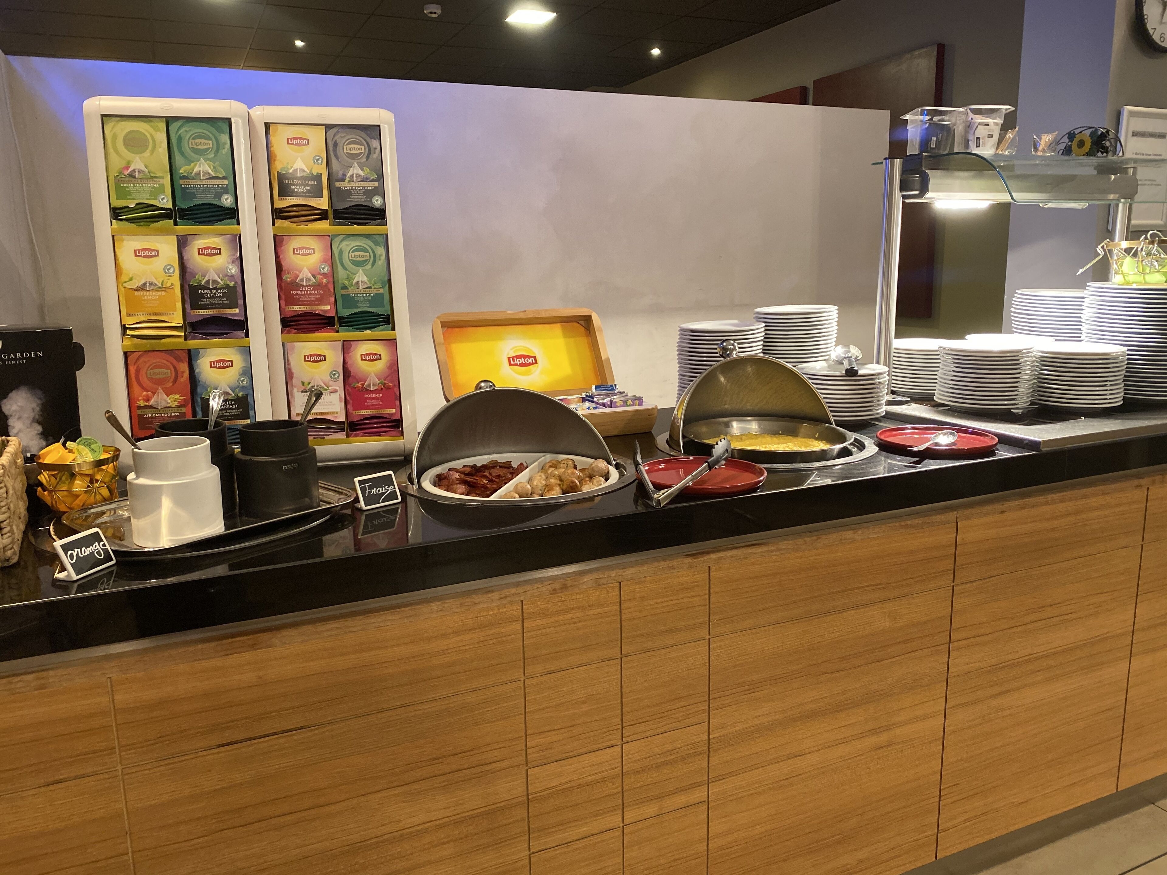 Un mostrador de buffet con diversos alimentos y cajas de té Lipton.