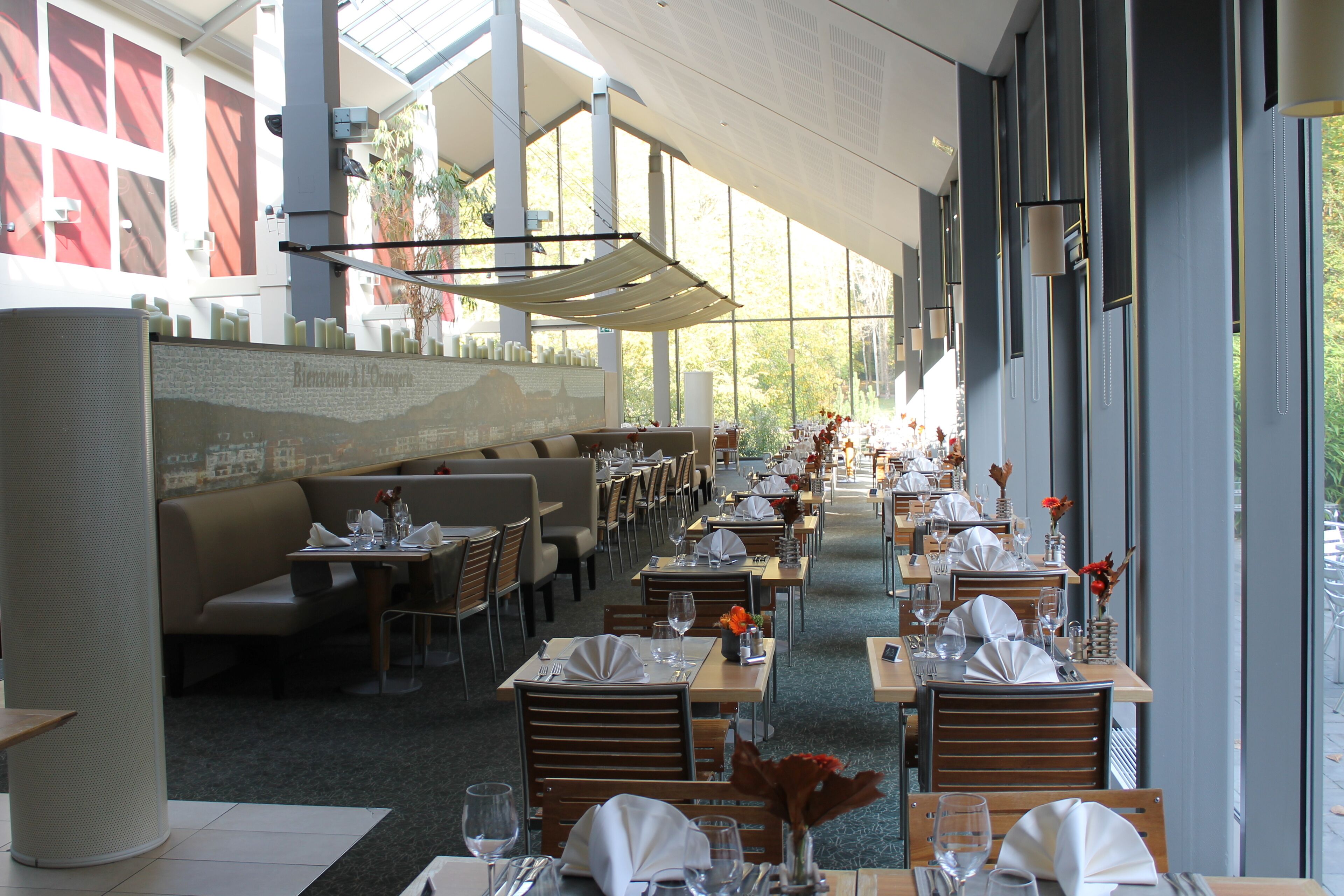 Un restaurante con varias mesas y cabinas, dispuesto en línea y con vista al exterior.