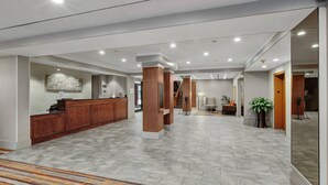 A spacious lobby with a reception desk, a staircase, and a seating area. - Delta Hotels by Marriott Baltimore North (Baltimore)
