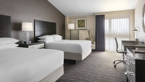 A hotel room with two beds, a desk, a chair, and a large window with curtains. - Delta Hotels by Marriott Baltimore North (Baltimore)