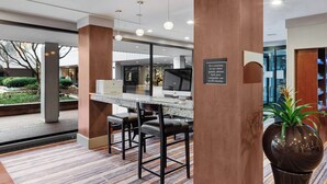 A modern hotel lobby with a reception desk, seating area, and a large potted plant. - Delta Hotels by Marriott Baltimore North (Baltimore)