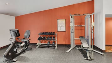 Un gimnàs amb equips cardiovasculars, pèses i màquines de musculació.