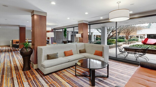 A modern lobby with a sectional sofa, a round coffee table, and a patterned carpet. - Delta Hotels by Marriott Baltimore North (Baltimore)