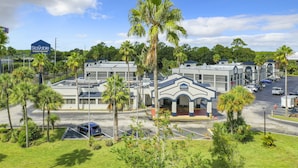 A Stayable Extended Stay Suites building with a parking lot and palm trees. - Stayable St. Augustine (St. Augustine)