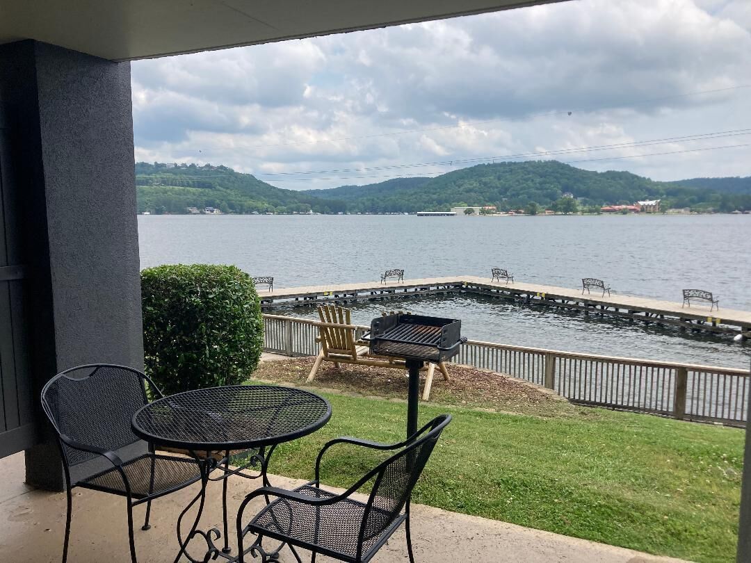 Une terrasse avec des sièges extérieurs et une vue sur un lac.