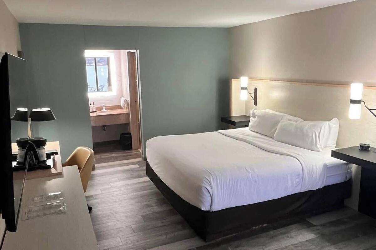 Une chambre d’hôtel moderne, dotée d’un grand lit, d’un bureau et d’une chaise.