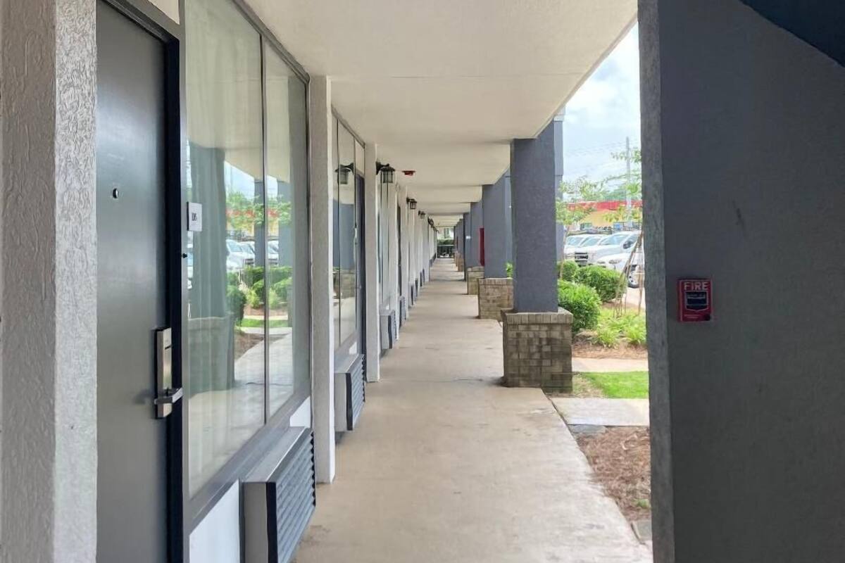 Un couloir couvert, doté de portes, de fenêtres et d’un détecteur d’incendie sur le mur de droite.